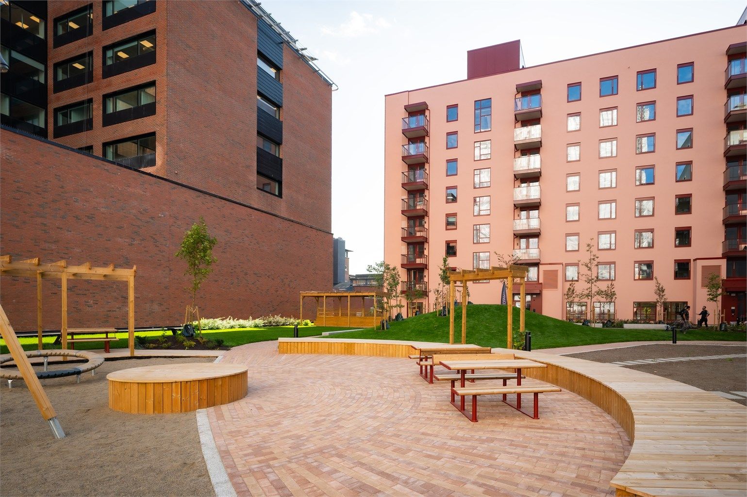 Skjermet og opparbeidet fellesareal med sittegrupper og lekeplass i bakgården.