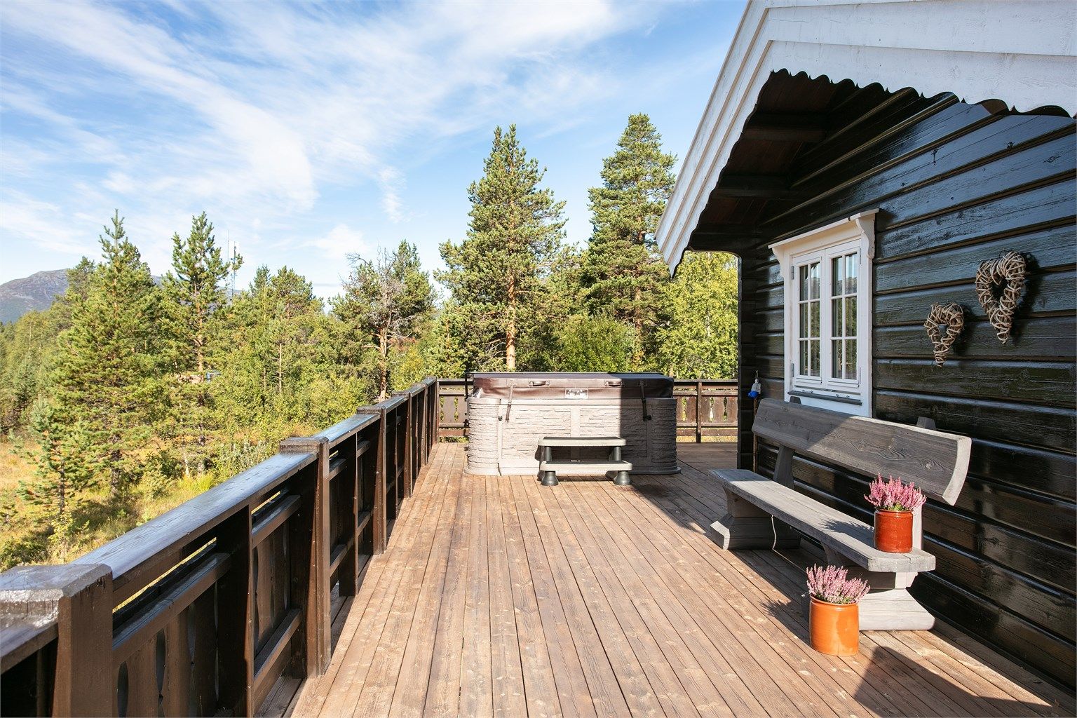 Stor terrasse med nedsenket jacuzzi og god plass til utemøbler.