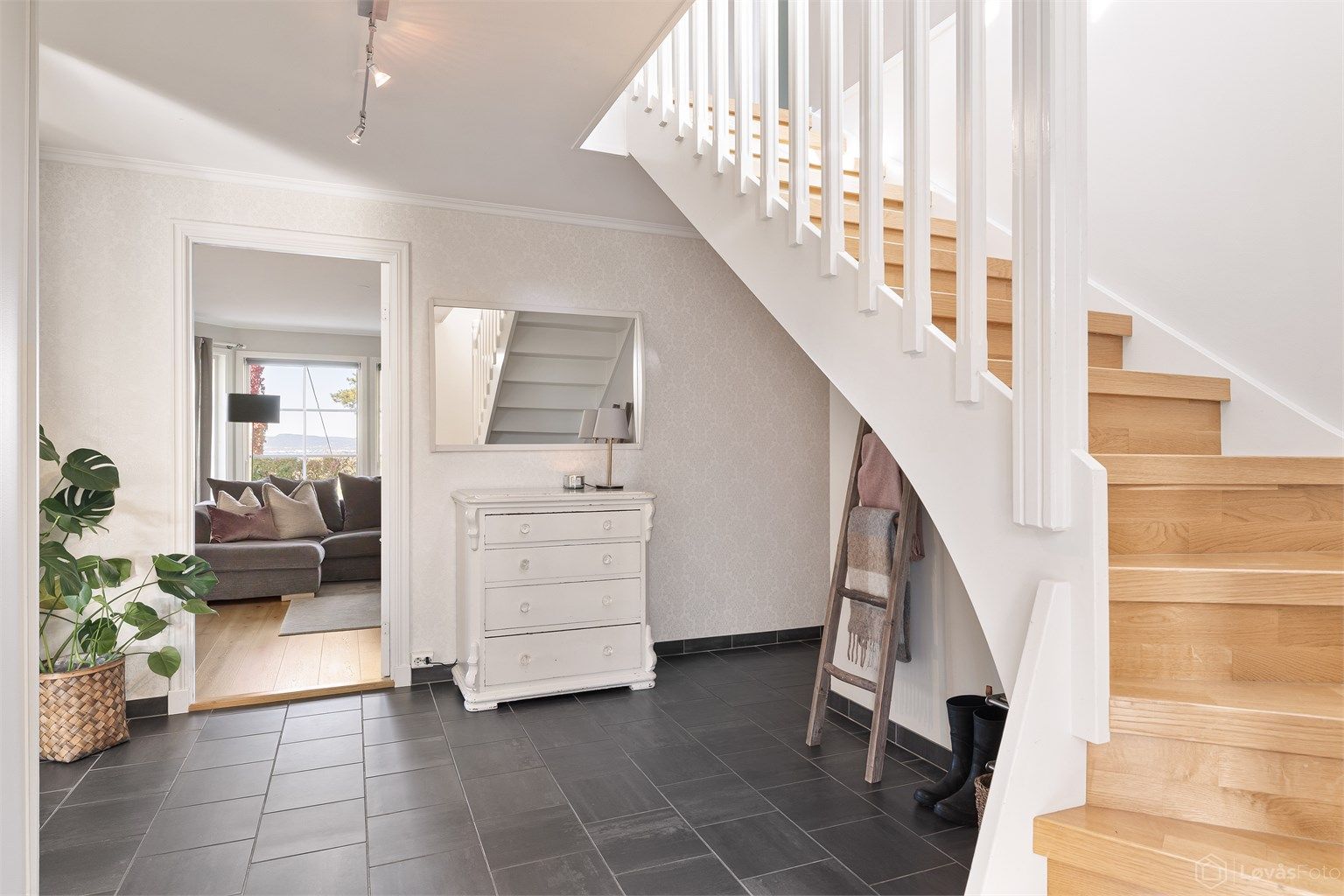 Romslig entré/hall med gulvfliser med gulvvarme og skyvedørsgarderobe