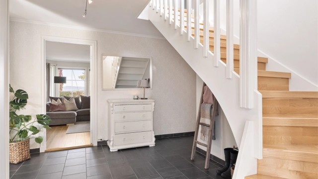 Romslig entré/hall med gulvfliser med gulvvarme og skyvedørsgarderobe