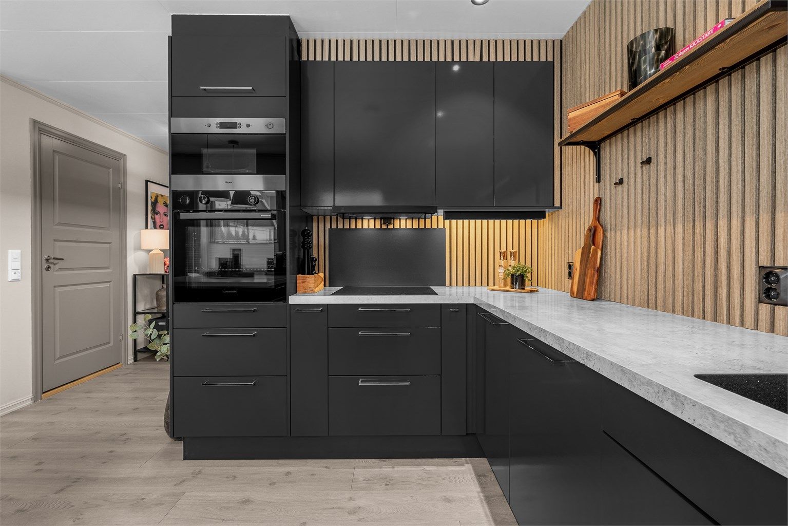 Stilren spilevegg som gir en god kontrast til det sorte kjøkkenet. 