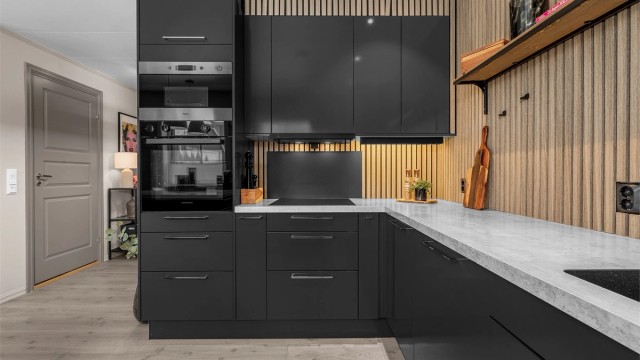 Stilren spilevegg som gir en god kontrast til det sorte kjøkkenet.