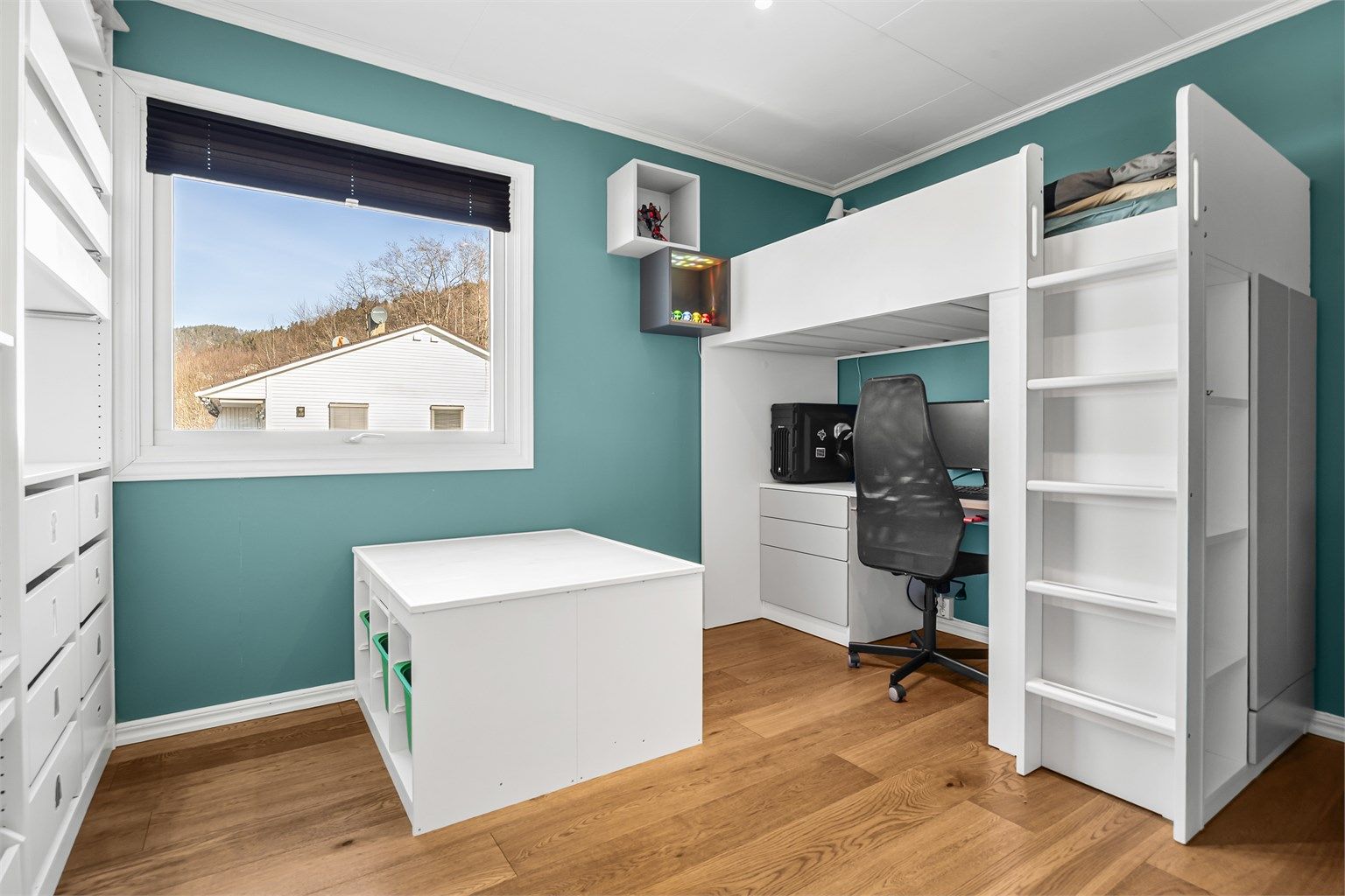 Det andre rommet i 1. etasje har en innebygget åpen garderobeløsning med hyller, skuffer og klesskinner.