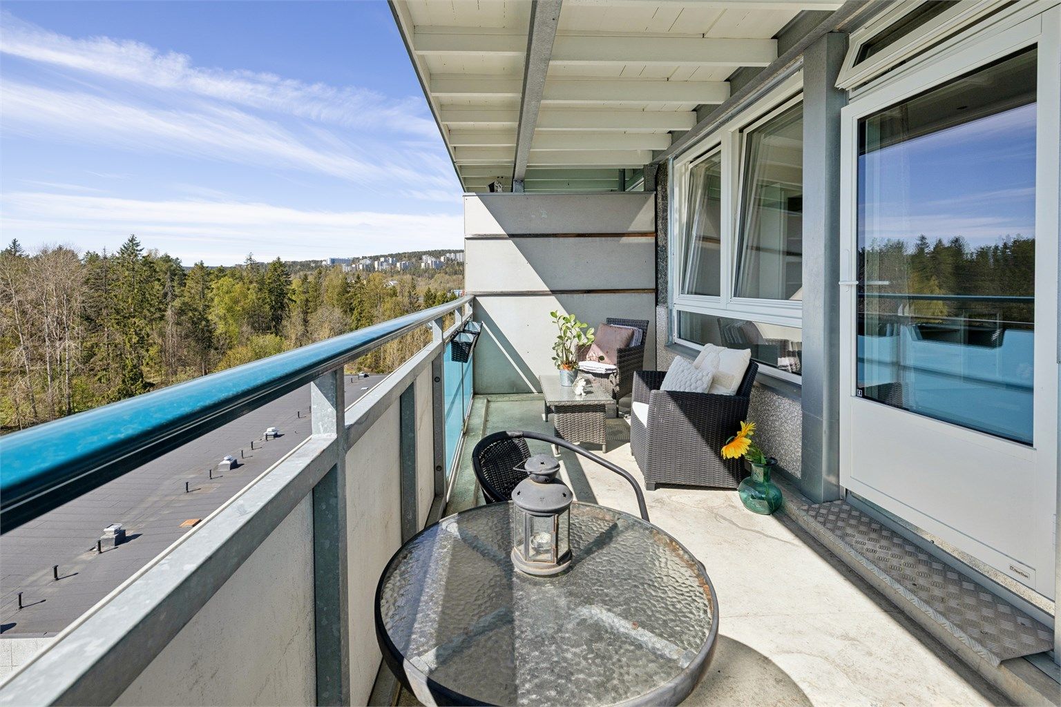 Utsikten fra balkongen strekker seg mot skogkanten, og gir en følelse av ro og natur.