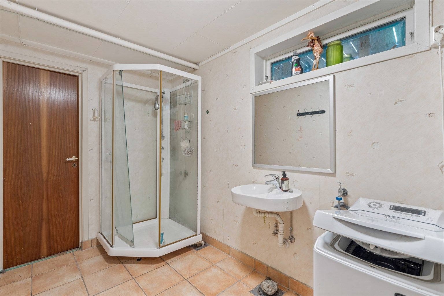 Badet er utstyrt med dusjkabinett og opplegg for vaskemaskin.