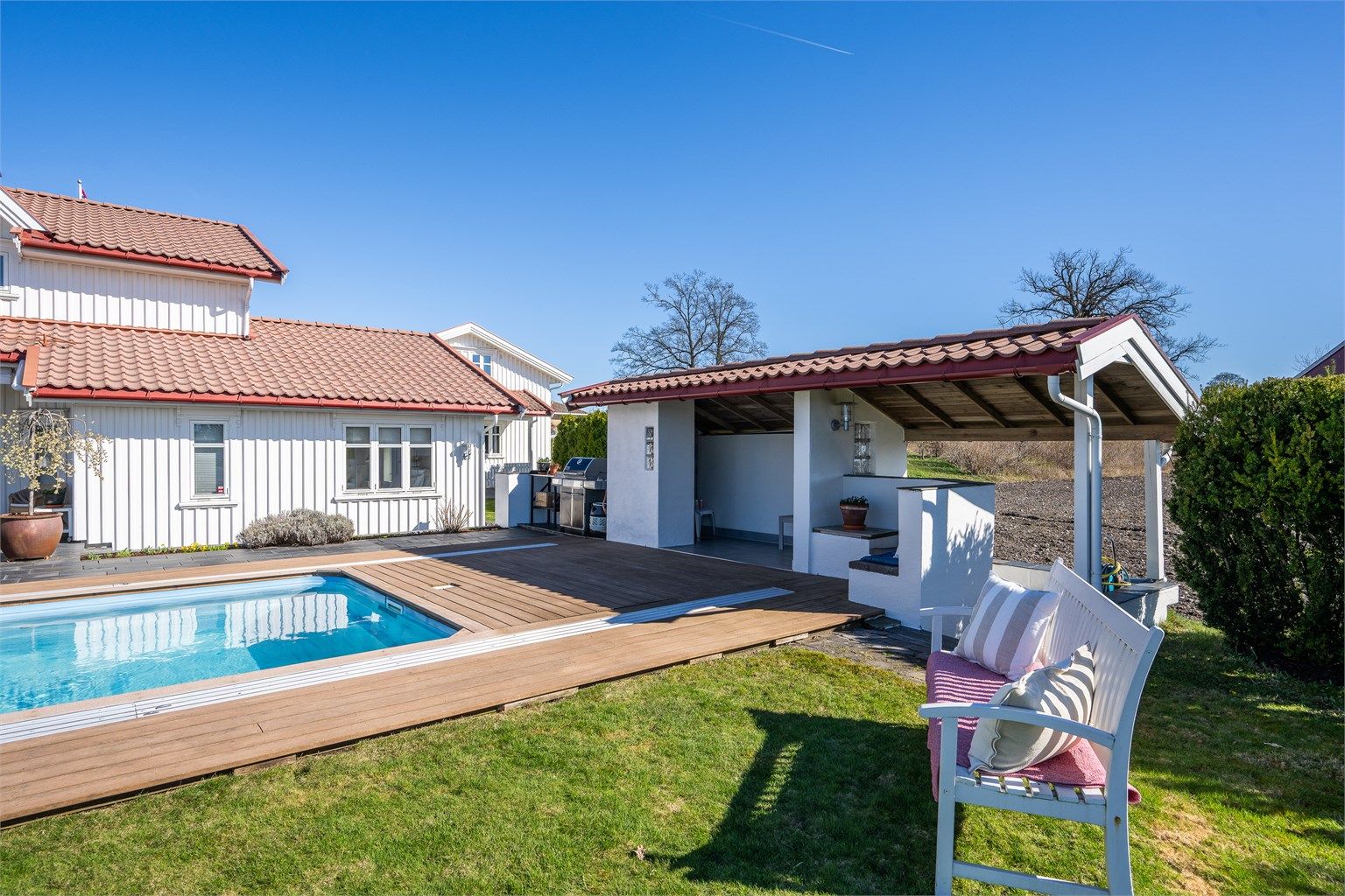 Badehuset har en overbygget sitteplass og en egen nisje med utedusj.