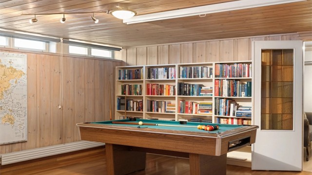 Plassbygde bokhyller gir rikelig med oppbevaring for bøker og spill.