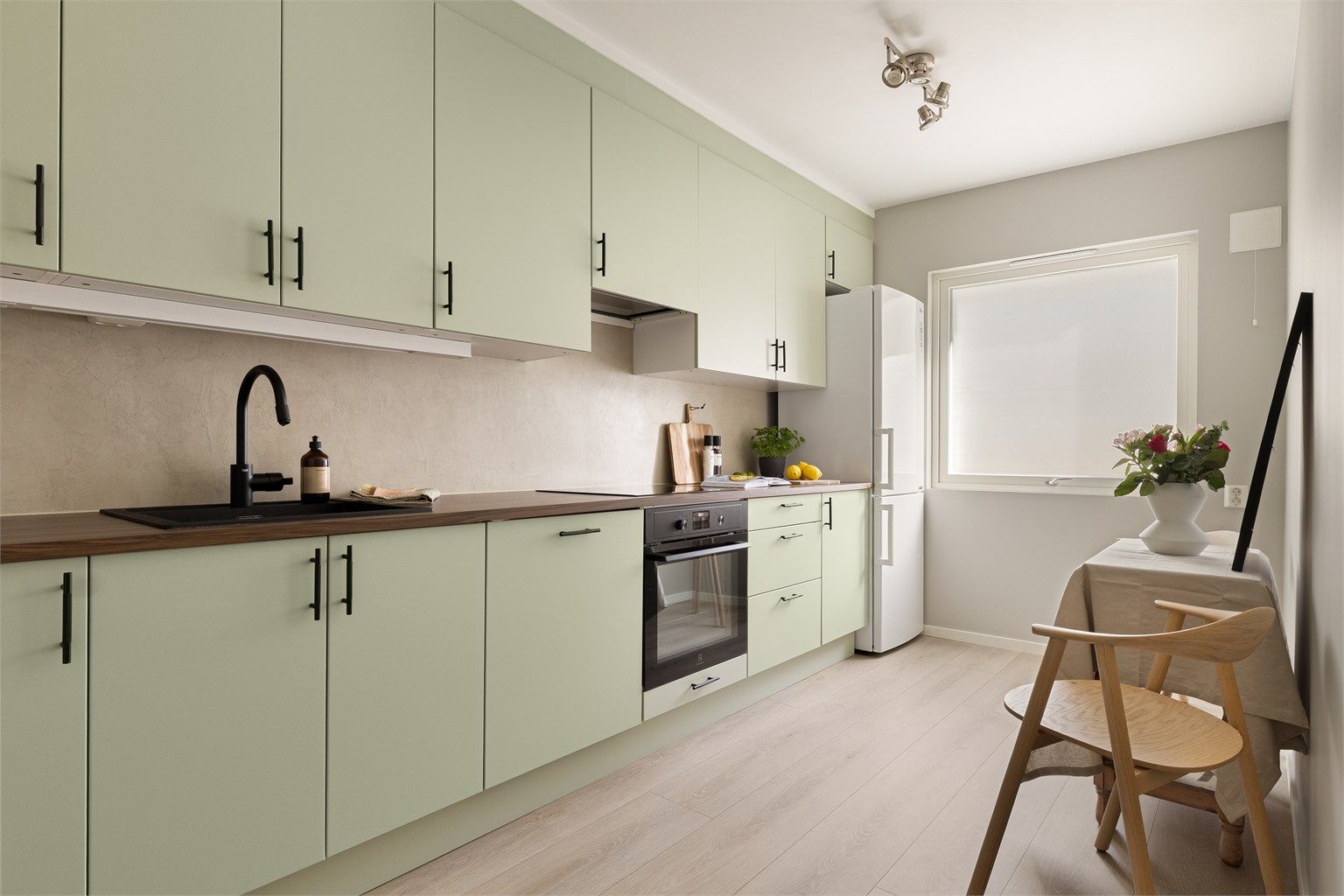 Lekkert kjøkken oppgradert i 2025/2026 med bla. ny benkeplate, lakkering av kjøkkenfronter, nye håndtak, nye integrerte hvitevarer og ny vask med blandebatteri.