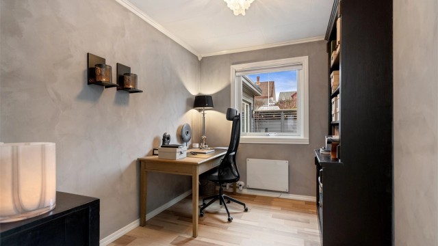 Det andre soverommet i etasjen har kalkmalte vegger og laminat på gulvet