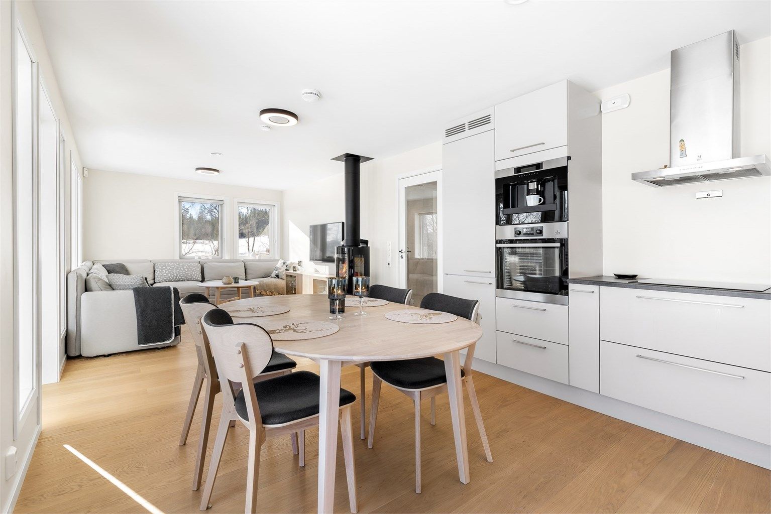 Åpen kjøkken- og stueløsning med flere store vindusflater som gir godt med lysinnslipp