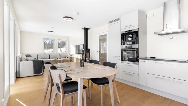 Åpen kjøkken- og stueløsning med flere store vindusflater som gir godt med lysinnslipp