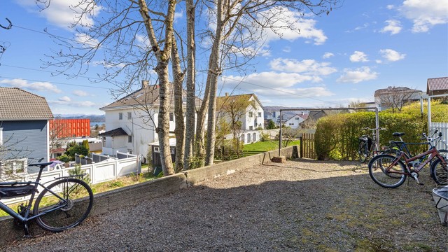God sykkeloppstillingsplass bak huset. Til høyre i bildet er porten inn mot hagen.
