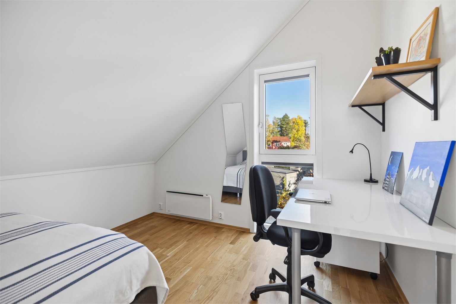 Boligens tredje soverom er lyst og trivelig, med store vinduer som gir rikelig med naturlig lys. En egen nisje gir god plass til en stor seng og bidrar til en lun og harmonisk atmosfære.