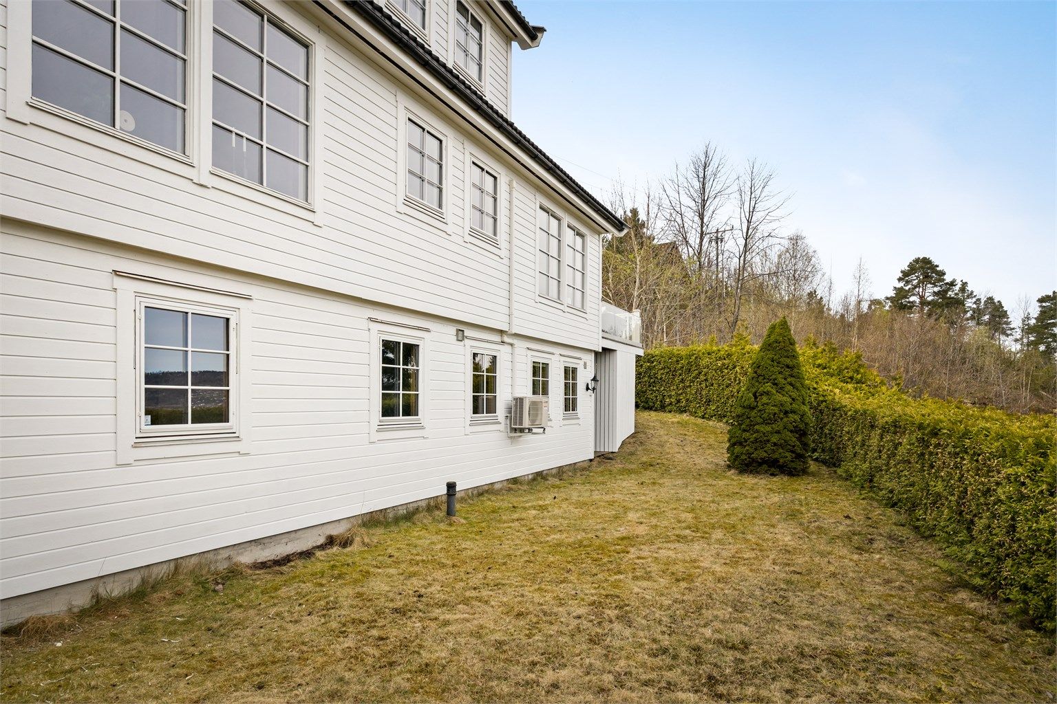 Hagen er opparbeidet med plenarealer og en hekk som rammer inn eiendommen.