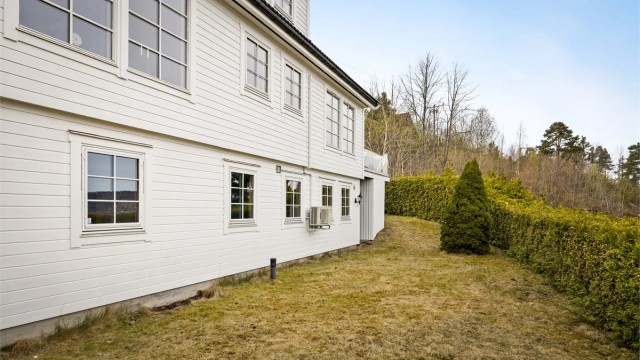 Hagen er opparbeidet med plenarealer og en hekk som rammer inn eiendommen.