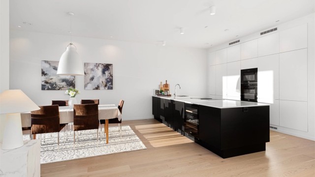 Kjøkken i åpen løsning mot stue med stor kjøkkenøy