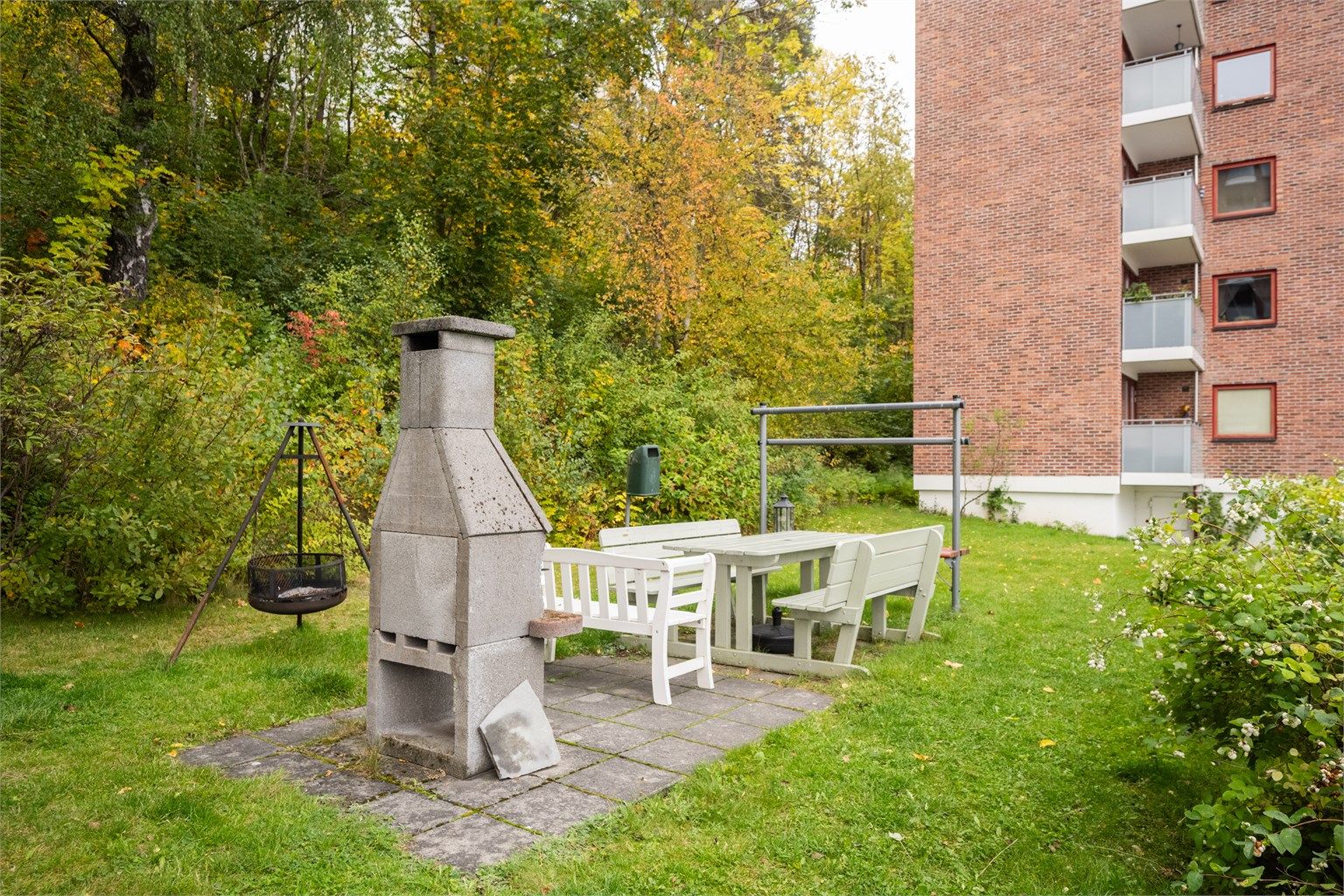 Grønt fellesområde med murt utepeis og benker for beboerne.