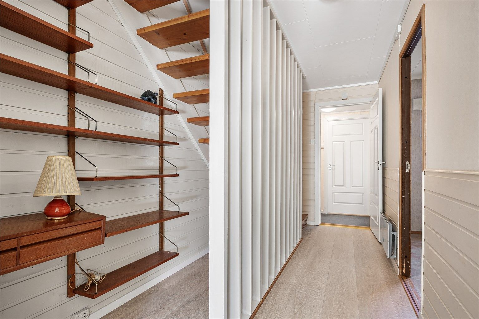 Under trappen er det et smart hyllesystem som gir ekstra oppbevaringsplass.