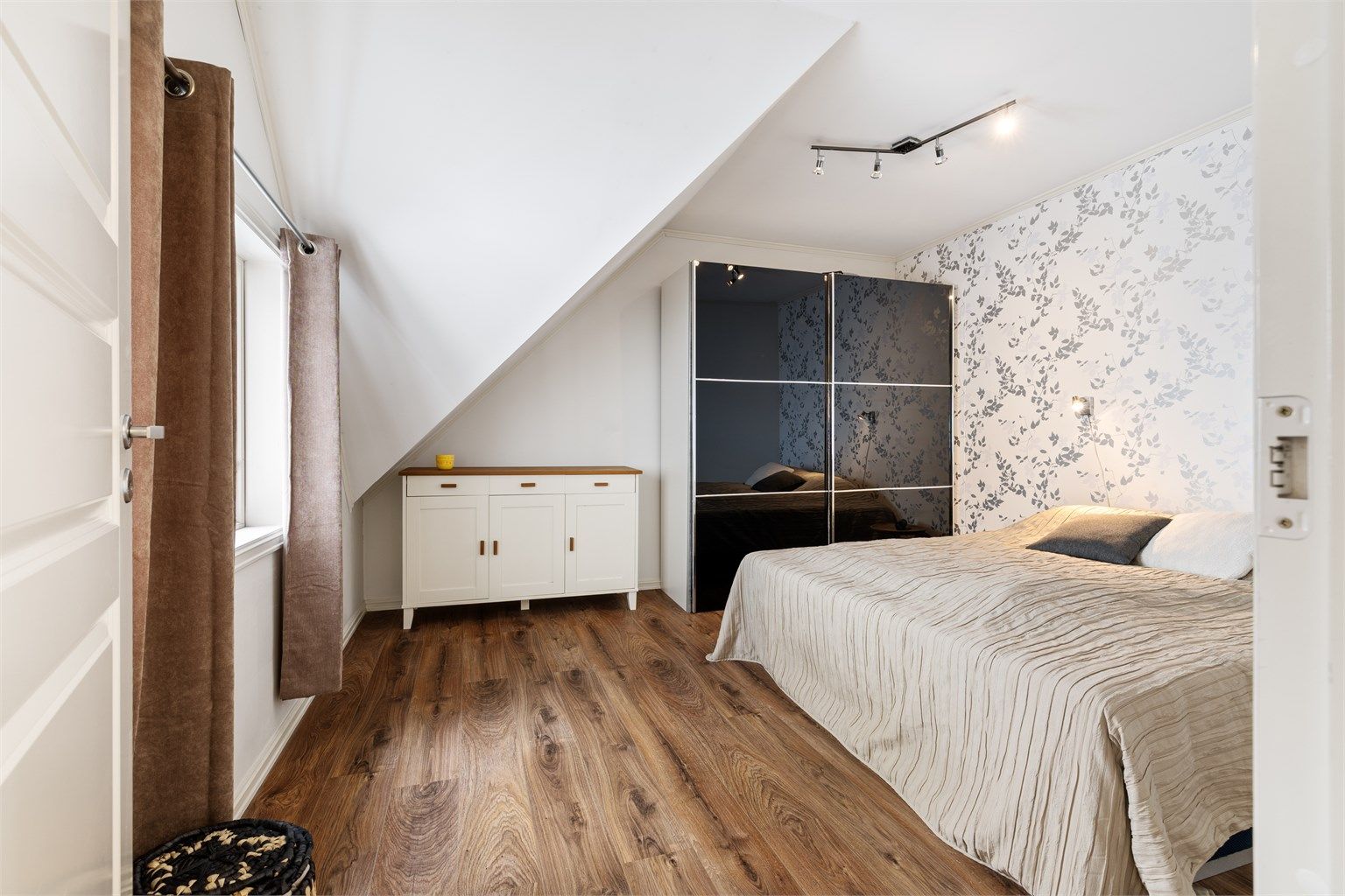 Rommet har god plass til dobbeltseng og oppbevaringsplass i frittstående skyvedørsgarderobe