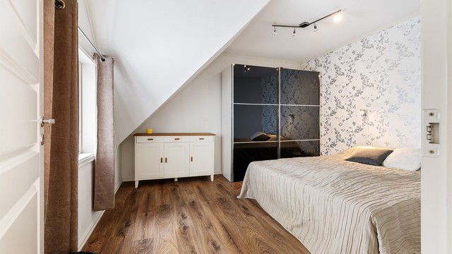 Rommet har god plass til dobbeltseng og oppbevaringsplass i frittstående skyvedørsgarderobe