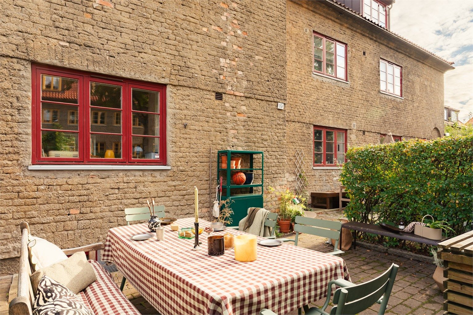 Den ene hageparsellen er også belagt med brostein og er en naturlig sone for å møblere med en sittegruppe.