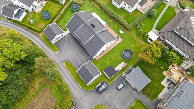 Tomt er opparbeidet med blant annet asfaltert gårdsplass, plenarealer og andre forskjellige beplantninger. Adkomst til boligen skjer via eget inngangsparti fra bakkeplan.