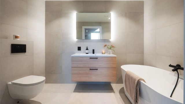 Etasjens andre bad er elegant utført med frittstående badekar.