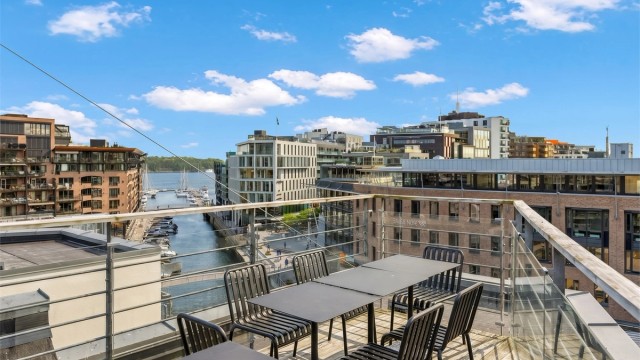 Sameiets felles takterrasse byr på sitteplasser og flott utsyn mot kanalen.