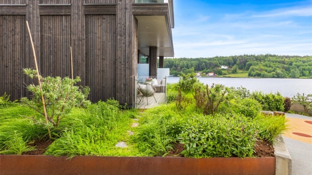 Uteområdene er pent opparbeidet med beplantning i cortenstål-kasser, gangstier og bryggeanlegg.