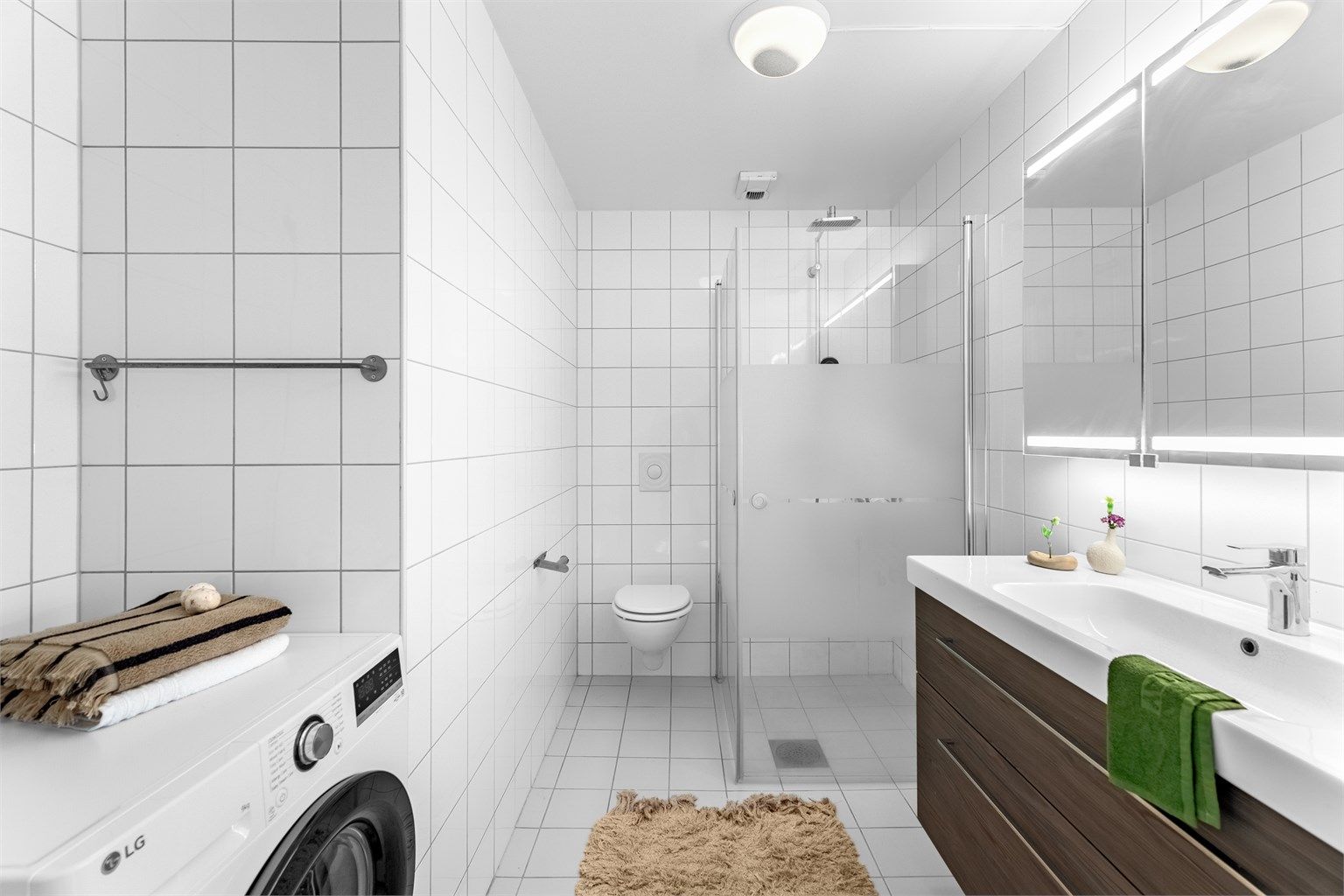 Pent fliselagt bad med gulvvarme og opplegg for vaskemaskin.