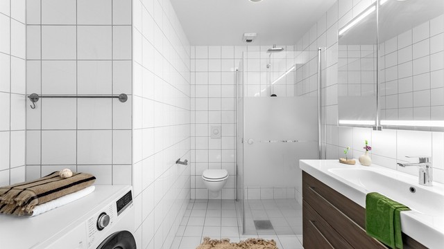 Pent fliselagt bad med gulvvarme og opplegg for vaskemaskin.