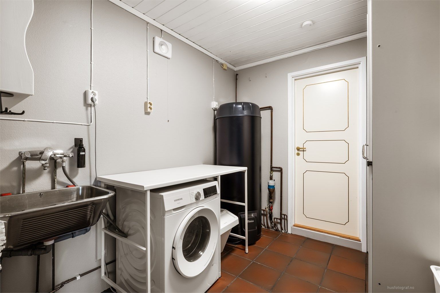 Separat vaskerom med gulvvarme, utslagsvask og opplegg for vaskemaskin. Her er også boligens 300 liters smart-varmtvannsbereder fra 2025 plassert.