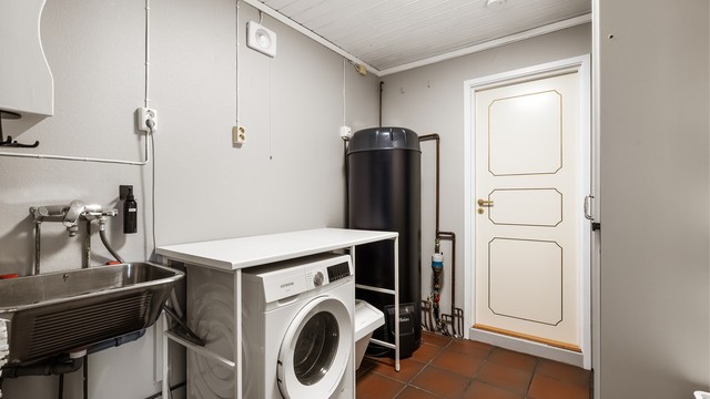 Separat vaskerom med gulvvarme, utslagsvask og opplegg for vaskemaskin. Her er også boligens 300 liters smart-varmtvannsbereder fra 2025 plassert.