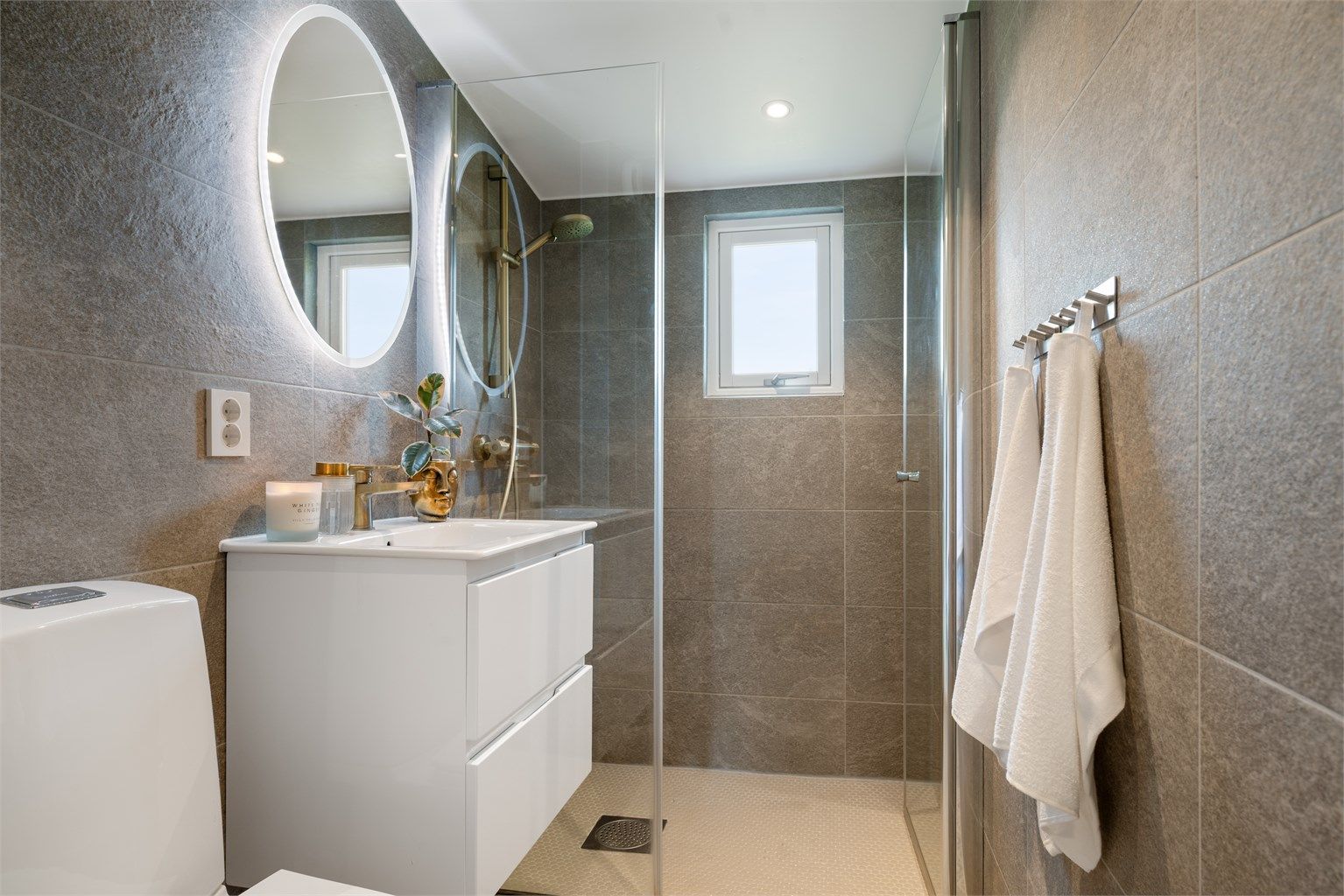 Badet er fra 2021 og har flislagt gulv med gulvvarme samt flislagte vegger.