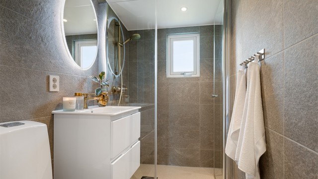 Badet er fra 2021 og har flislagt gulv med gulvvarme samt flislagte vegger.