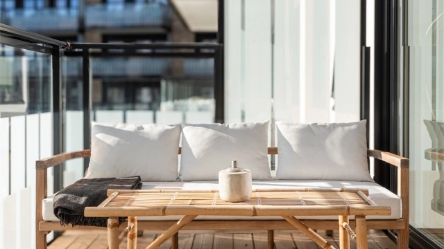 Skjermet uteplass med overbygg og glassrekkverk.