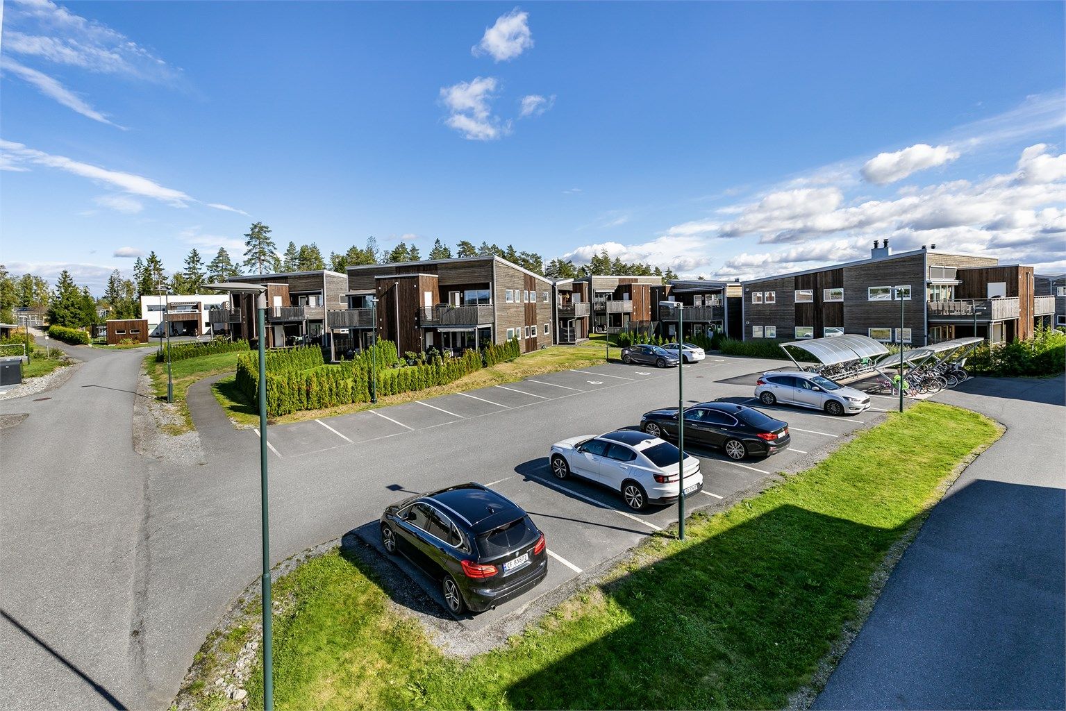 Det er få meter til og fra biloppstillingsområdet der leiligheten disponerer en oppmerket plass, med lader til EL-bil.