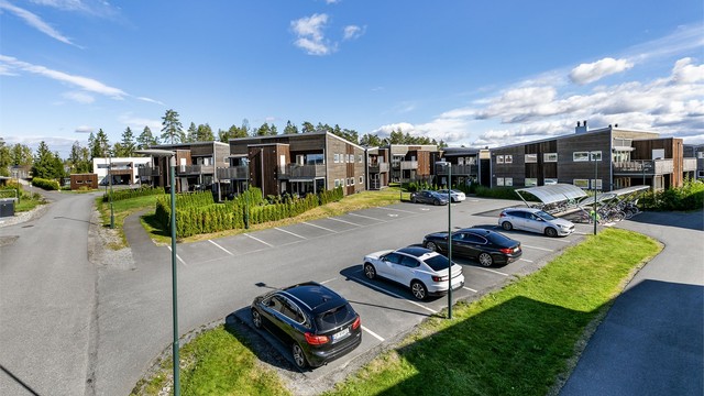 Det er få meter til og fra biloppstillingsområdet der leiligheten disponerer en oppmerket plass, med lader til EL-bil.