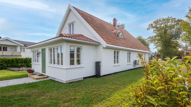Tomten er pent opparbeidet med grønne plenarealer, frodig beplantning og etablerte trær som gir eiendommen en hyggelig og innbydende atmosfære.