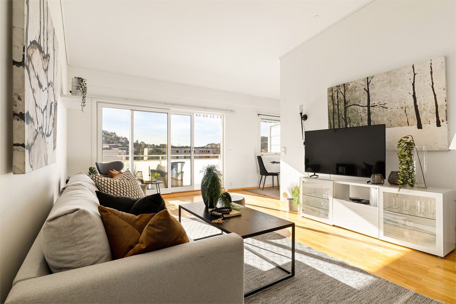 Romslig stue med generøs takhøyde og plass til sofagruppe og ønsket møblement.