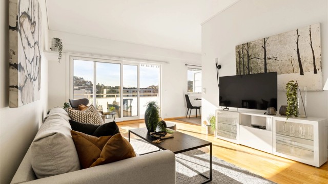 Romslig stue med generøs takhøyde og plass til sofagruppe og ønsket møblement.