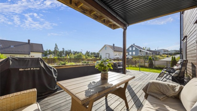 Boligen har en delvis overbygd terrasse og stort plenareal.