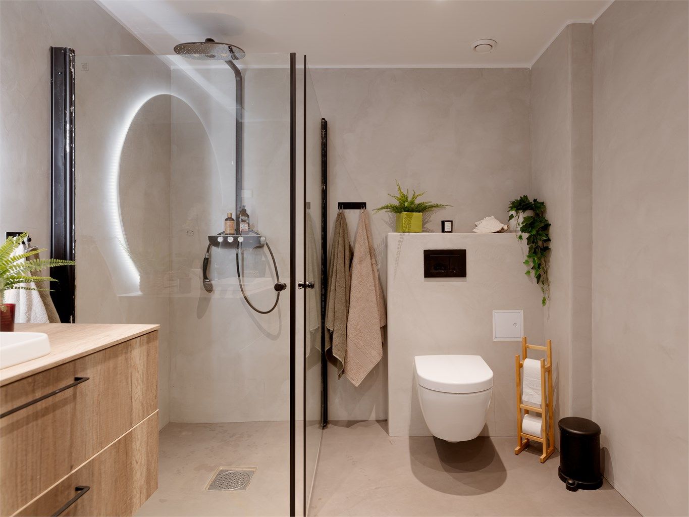 Innredningen består av porselensservant nedfelt i laminat benkeplate med underliggende skap, veggmontert speil med integrert lyslist, veggklosett og dusjnisje med svingbare glassvegger i herdet glass. Opplegg til vaskemaskin.