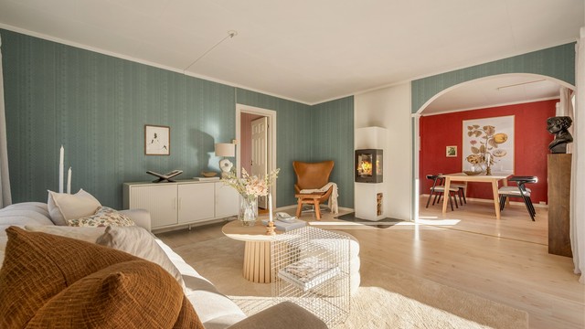 Stuen er utstyrt med en moderne peis, har buegang fra spisestuen og adkomst til soverommet.