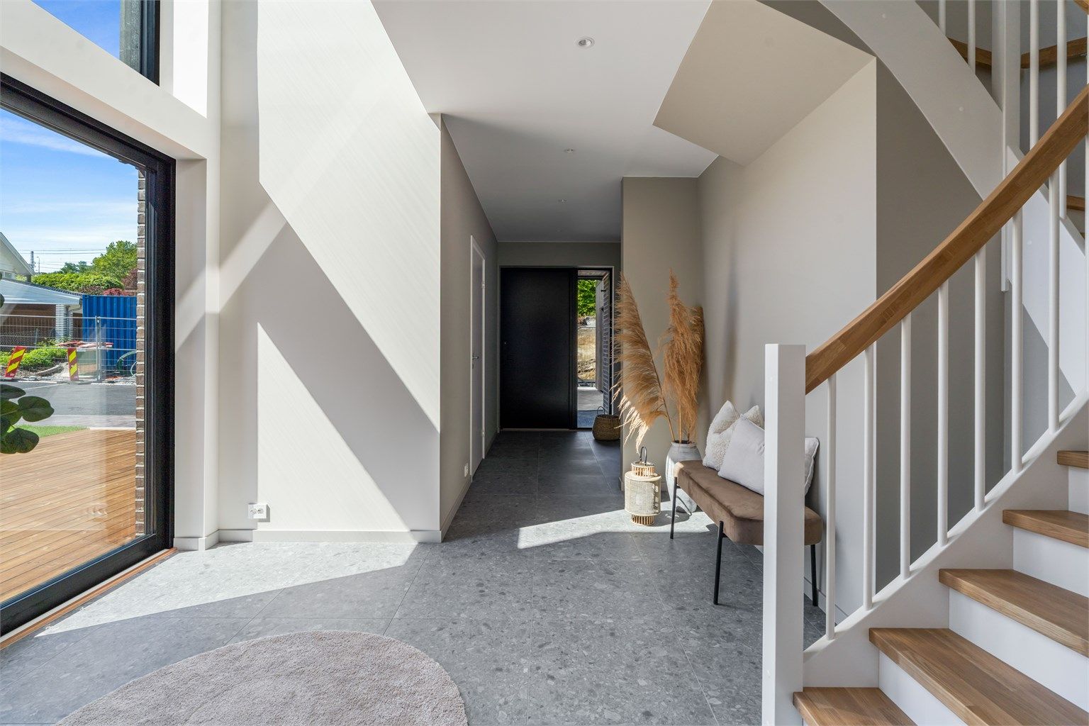 Gang / hall i 1 etg, mot inngangsdør.  Gulvet er belagt med 60x60 fliser og det vannbåren varme i gulvene i huset.
Til høyre for inngangsdør ligger det bad med dusj, mens til høyre ligger vaskerommet. Der er det også utgang til gårdsrom og garasje.