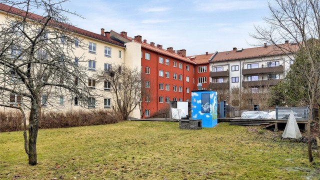 Prisbelønnet bakgård med grill, utekino og flere større separate sittegrupper.