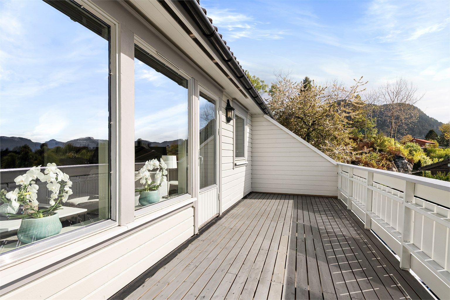 Balkongen er i trekonstruksjon med terrassebord, og har god plass til en sittegruppe.