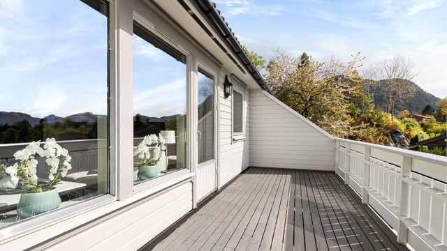 Balkongen er i trekonstruksjon med terrassebord, og har god plass til en sittegruppe.
