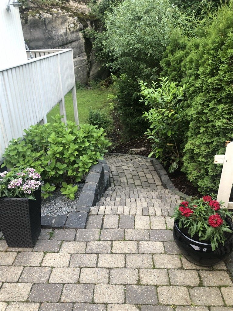 Eiendommen er pent opparbeidet, her trapp fra uteplass ned til usjenert stor hage med god plass til lek og morro. 
