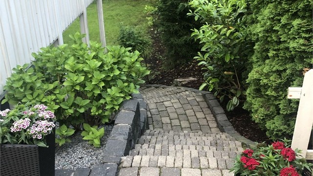 Eiendommen er pent opparbeidet, her trapp fra uteplass ned til usjenert stor hage med god plass til lek og morro.